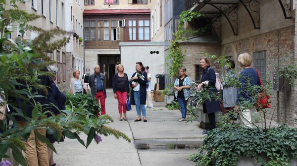 Eine Gruppe von Menschen in einem Innenhof mit Bepflanzung